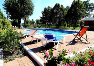a patio with two chairs and a swimming pool at Isola Di Wight in San Michele al Tagliamento