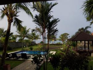 a resort with a swimming pool and palm trees at Khalisha Villas in Airsatang