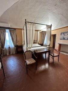 a room with a table and a bench and a chair at Abbazia delle Sorelle in Novello +23 photos