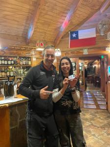 a man and a woman posing for a picture in a bar at NATIVA MOUNTAIN SUITES in Malalcahuello