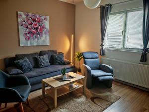 a living room with a couch and two chairs and a table at Apartman - sobe Corina-blizu Osijeka in Bilje