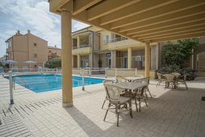 a patio with a table and chairs next to a pool at Hotel Residence Il Conero 2 in Numana