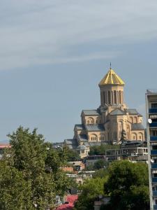 een gebouw met een toren op een heuvel bij Hotel-Apartment NMP in Tbilisi City