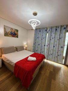 ein Schlafzimmer mit einem Bett mit einer roten Decke und einem Fenster in der Unterkunft Appartement Casa-marina au 10ème étage in Casablanca + 35 Fotos