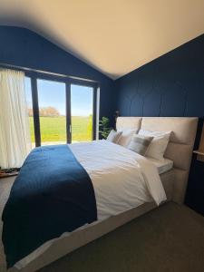 a bedroom with a large bed with a large window at Luxe appartement met uitzicht in Slootdorp