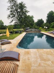 a swimming pool with two loungers and a patio at Moulin Neuf in Champlitte-la-Ville