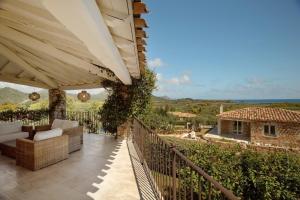 une terrasse avec vue sur une maison dans l'établissement Villa Gelsomino a soli 500 mt dal mare con piscina privata e vista mare, à Castiadas