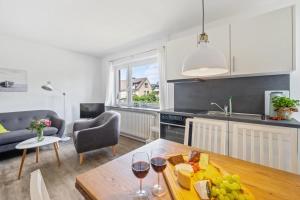 Una cocina y una sala de estar con una mesa con copas de vino. en Wiebke, en Büsum