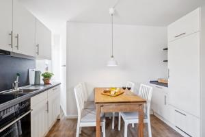 Una cocina con una mesa de madera y gabinetes blancos. en Wiebke, en Büsum