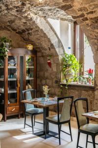 a table and chairs in a room with a stone wall at VILLA AGOSTINO LUXURY B&b in Vico Equense