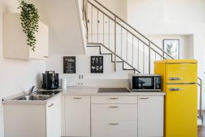 a kitchen with white cabinets and a yellow refrigerator at Fantastic Loft with Balcony in Berlin