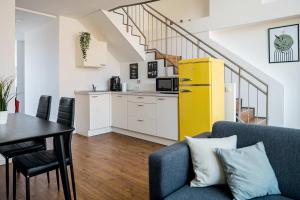 a living room with a couch and a table and a kitchen at Fantastic Loft with Balcony in Berlin