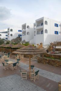 a patio with tables and chairs and a building at Alykes in Marmari