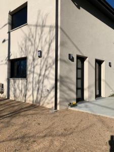 a shadow of a tree on the side of a building at Sur côte en Dombes in Villette-sur-ain +17 photos