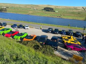 a group of cars parked in a parking lot next to a river at Turnpike by Maya Hotel & Restaurant in Rishworth
