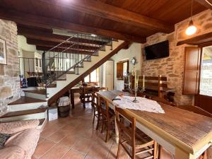a dining room with a wooden table and a staircase at La casetta nel bosco in Pedana