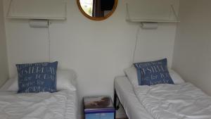 Amalia في نيس: غرفة معيشة مع كنبتين بيضاء ومرآة