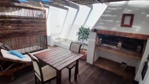 porche con mesa de madera y chimenea en View from the Hill room 1, en Mossel Bay