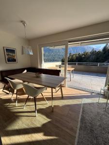 a living room with a table and chairs and a large window at Panorama Apartment Imst in Imst