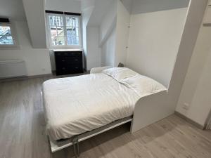 a white bed in a room with a window at Le Ptit Vaucelles in Pont-lʼÉvêque