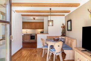 une cuisine et une salle à manger avec une table et des chaises dans l'établissement Ferienhaus Frühholz - Fewo Wank, à Grainau