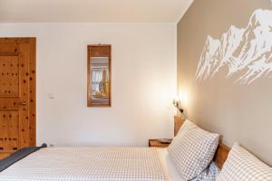 une chambre avec un lit et un miroir au mur dans l'établissement Ferienhaus Frühholz - Fewo Wank, à Grainau