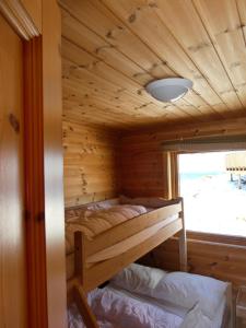 a bedroom in a log cabin with a bunk bed at Helligvær Kystopplevelser AS in Helligvær