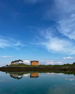 two houses on the shore of a body of water at Helligvær Kystopplevelser AS in Helligvær