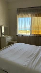 een slaapkamer met een groot wit bed en een raam bij Appartement Playa de Tanger/ Marina Bay in Tanger +12 foto's