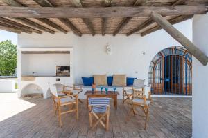 une terrasse avec des chaises, des tables et un canapé dans l'établissement True Local Village, à Loulé