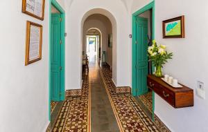 a hallway with green doors and a tile floor at Casa De Las Bovedas in Rosal de la Frontera