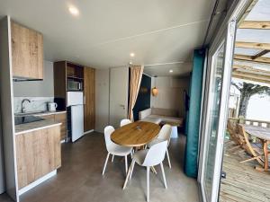 a kitchen and dining room with a wooden table and chairs at Camping Point Vert in Serrières-de-Briord