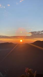a sunset over the mountains with the sun in the sky at Sparid Inn in Darjeeling