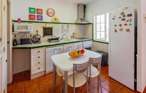 a kitchen with a white table and a white refrigerator at Awesome Home In Islantilla - Lepe in Islantilla