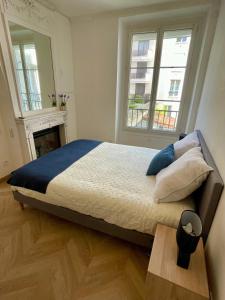 a bedroom with a large bed with two windows at Appartement Convention Maridor 3 in Paris