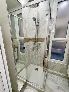 a shower with a glass door in a bathroom at Appartement Convention Maridor 3 in Paris