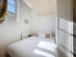 a white bed in a white room with a window at Les Vignes 3 Chambres avec Salle de bain privative in Anse +14 photos