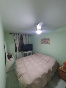 テラサにあるHabitación privada dobleのベッドルーム(白いベッド1台、天井ファン付)