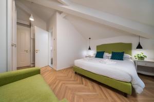 a bedroom with a large bed with green accents at B&B PIEDICASTELLO in Trento