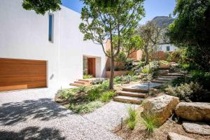 a house with a garden with stairs and rocks at Noordhoek Sunset Villa in Flat Acres