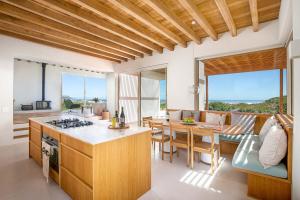 a kitchen and living room with a table and chairs at Noordhoek Sunset Villa in Flat Acres