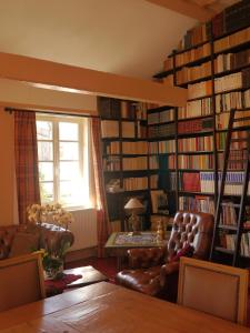un salon rempli de nombreux livres dans l'établissement Le Puits D'Angle, à Thibivillers