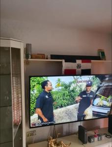 テラサにあるHabitación privada dobleの2人の警察官が映っている薄型テレビ
