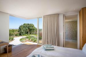 a bedroom with a bed and a large window at Noordhoek Sunset Villa in Flat Acres