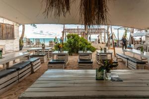 a restaurant with tables and chairs on the beach at B4 Beach Club and Hotel in Paje