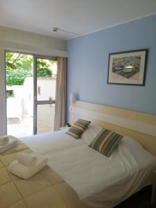 a bedroom with a large white bed with a window at Thermotel in Dax +26 photos