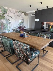 a dining room with a wooden table and chairs at Bad Seerose mit Seeblick, Dachterrasse, Pool und Sauna in Bad Saarow +23 photos