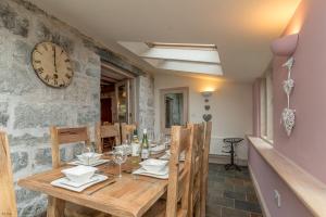 ペンリンダイドライスにあるRhiwgochのダイニングルーム(木製テーブル、壁掛け時計付)