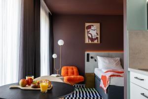 a hotel room with a bed and a table with fruit on it at kalm stay - munich east in Munich