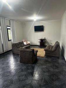 a living room with two couches and a flat screen tv at Casa Natalino Broleze in Águas de Lindóia